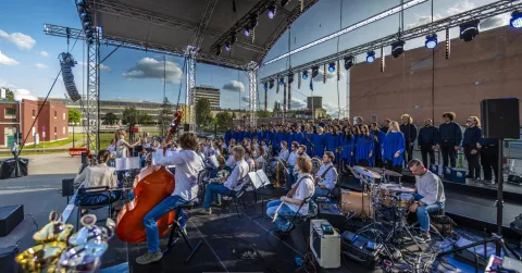 grupa artystów muzycznych występująca na scenie w plenerze